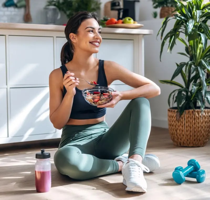 Woman eating next to exercise equipment